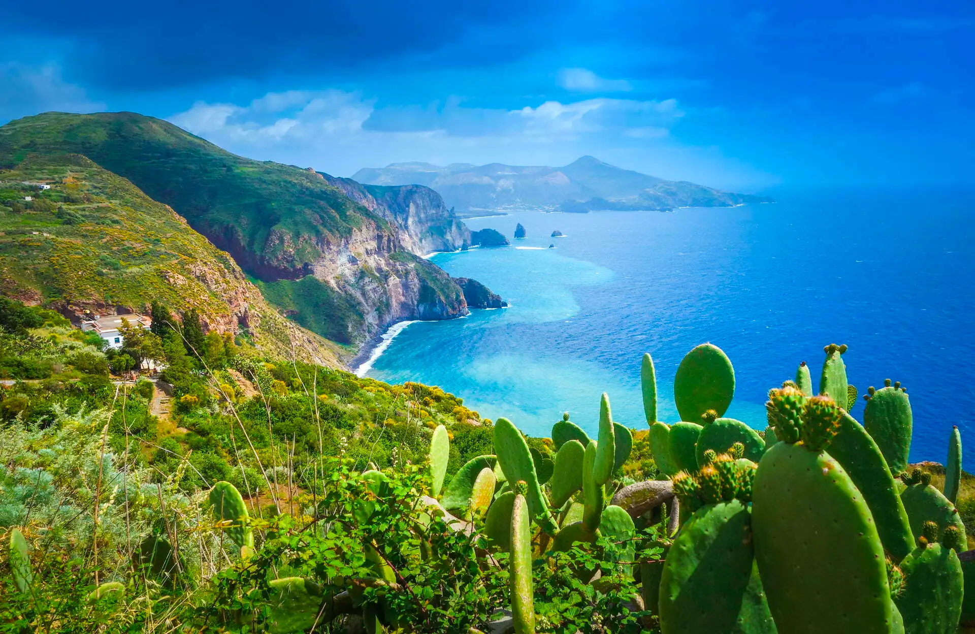 Lipari island - Echonautique.com Scenic coastal view of Lipari Island with lush cliffs and turquoise sea, Aeolian Islands