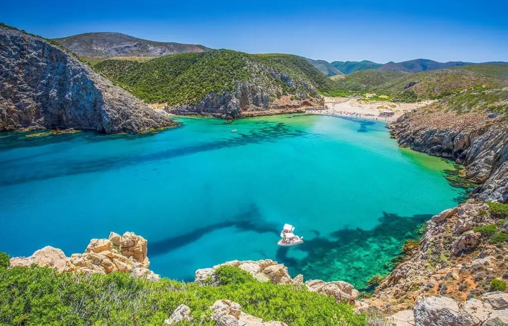 Cala Domestica bay with turquoise water and anchored yacht, Sardinia, Italy