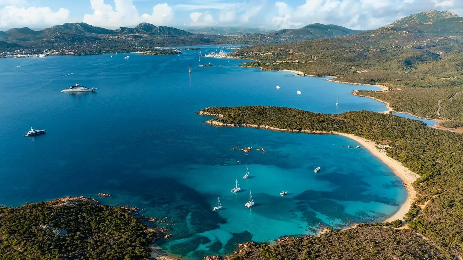 Aerial view of Cala di Volpe Bay with yachts anchored in Costa Smeralda, Sardinia