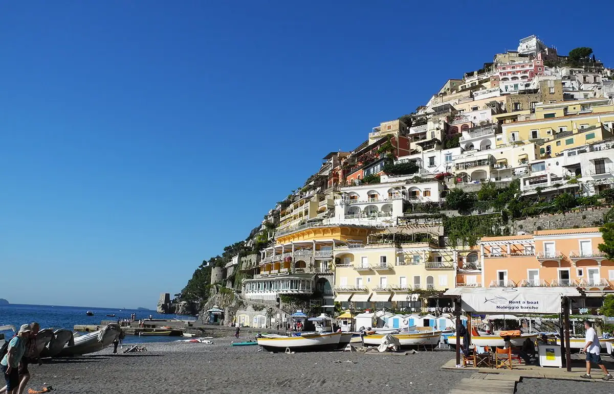 Colorful cliffside buildings and boats along the beach in Positano, Amalfi Coast