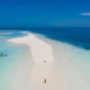 Aerial view of a man walking on the white sand bar in the tropic - Echonautique.com Polynesia