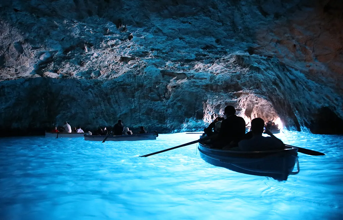 Blue Grotto Capri Amalfi Coast Yacht Charter - Echonautique.com Visitors exploring the Blue Grotto in Capri during an Amalfi Coast yacht charter