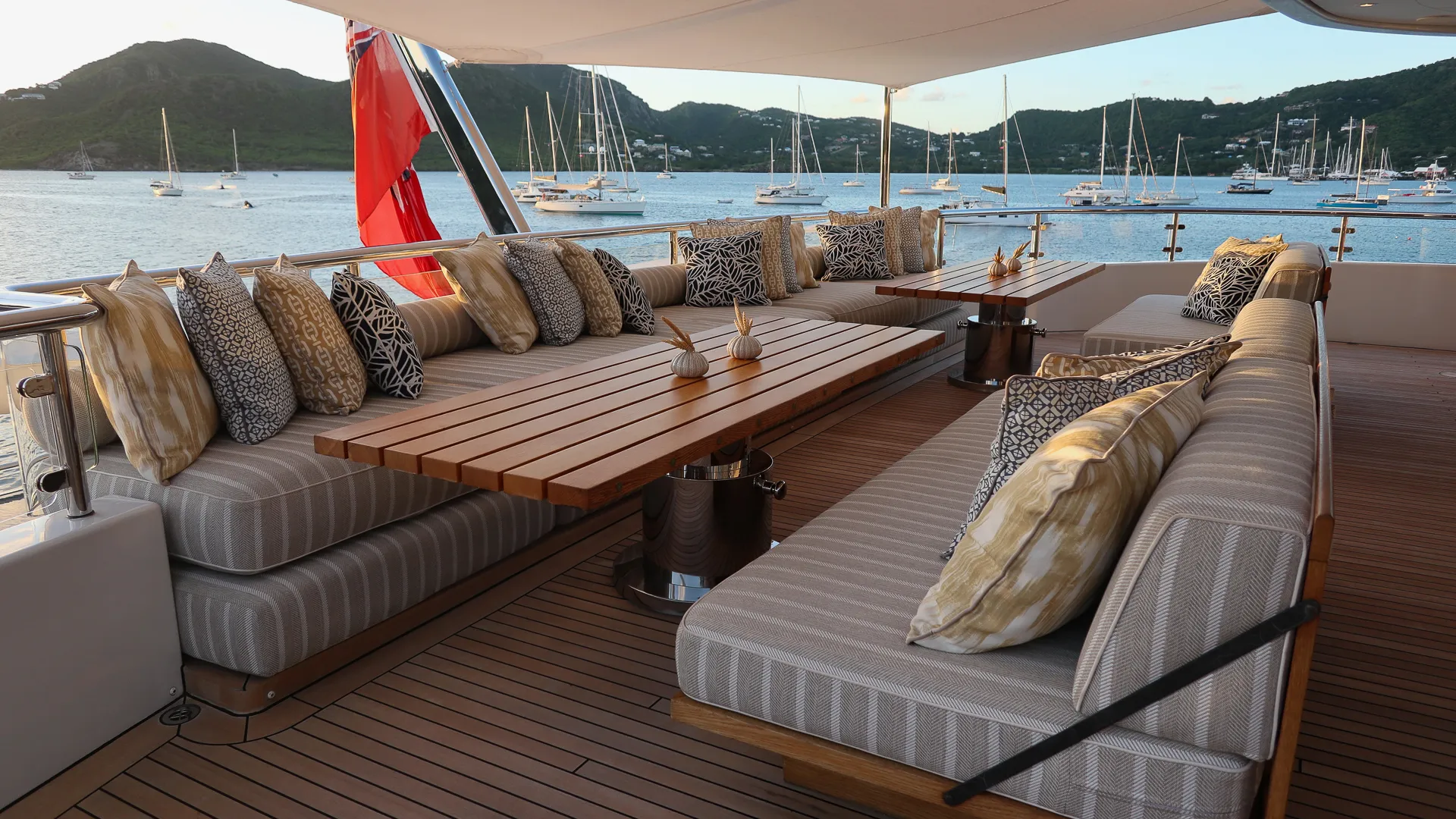 Luxury yacht aft deck seating area at anchor during sunset